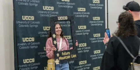 student posing in a photo booth for mountain lion visit day